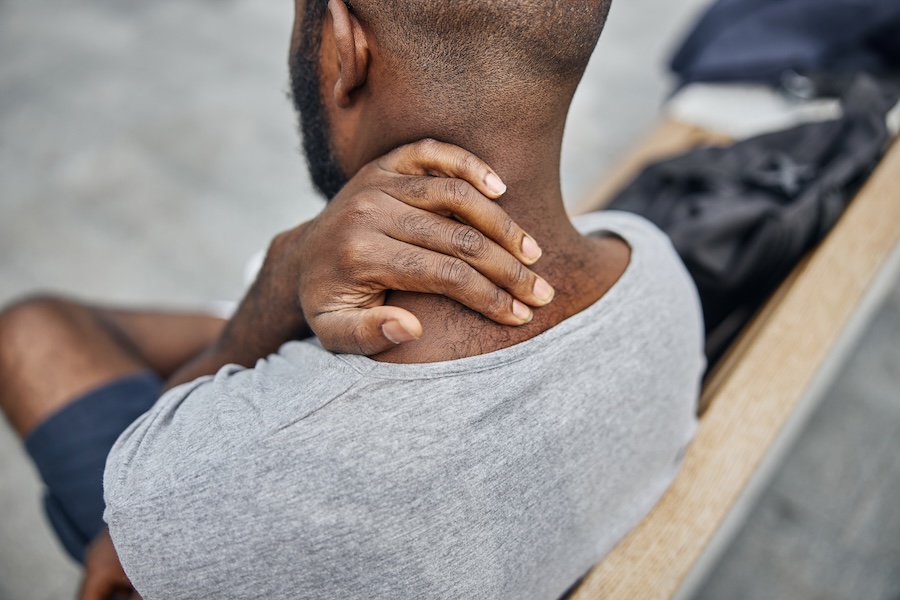 Man touching his neck from pain